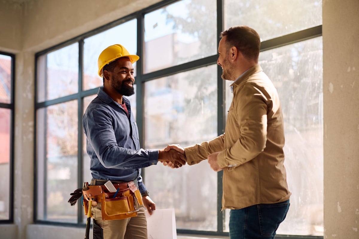 Contractor shaking hands with a homeowner at a project site